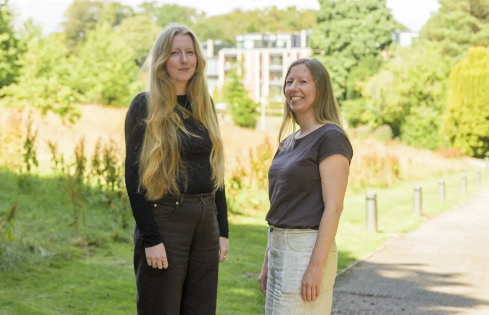 Aiesha and Karen from the Housing Options Scotland team, standing together on a sunny path