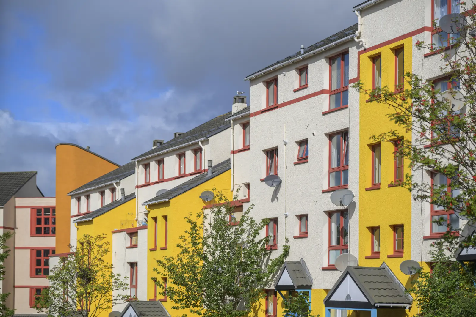 A row of colourful flats with yellow and white walls