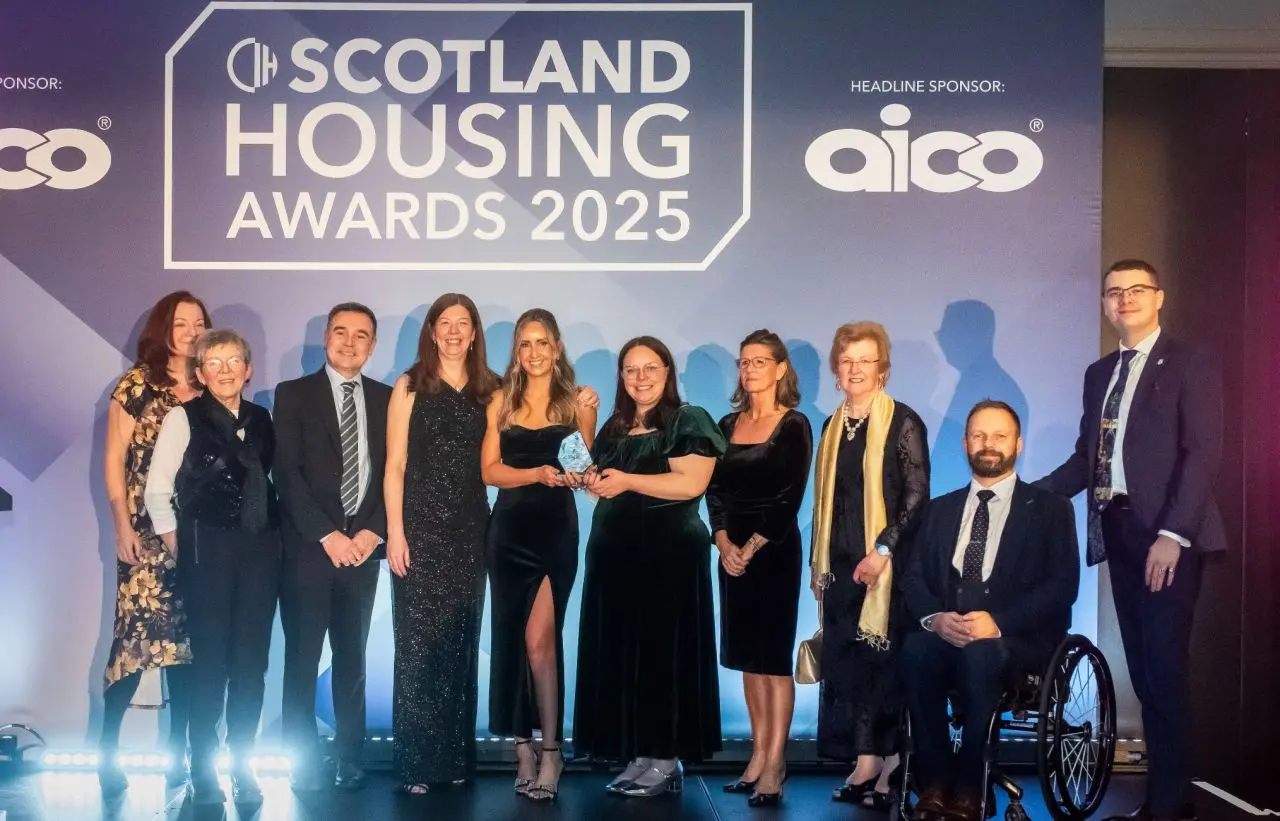 The Hospital Housing Clinic team on stage at the Scotland Housing Awards 2025 holding their trophy
