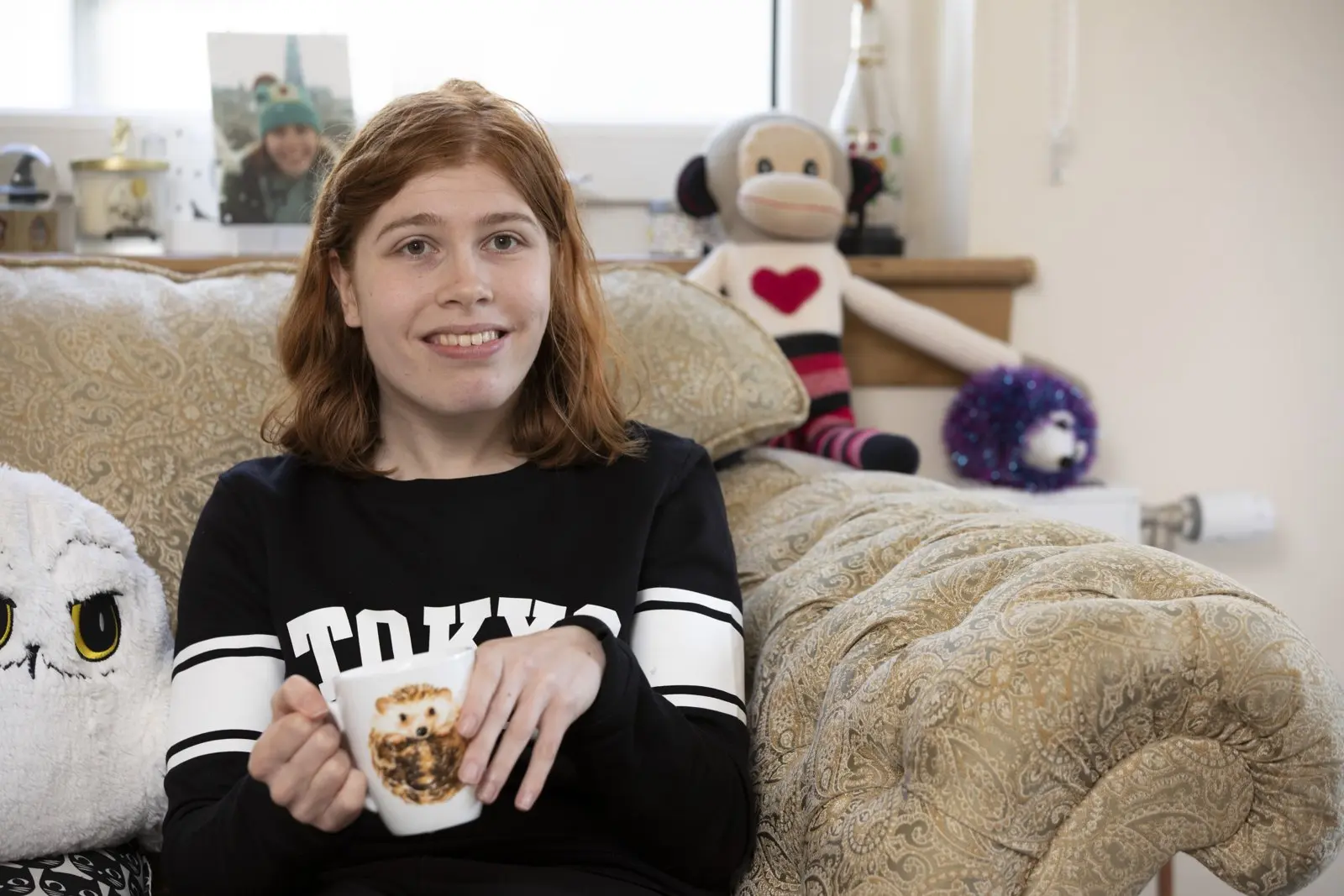 Lucy at home, holding a mug of tea